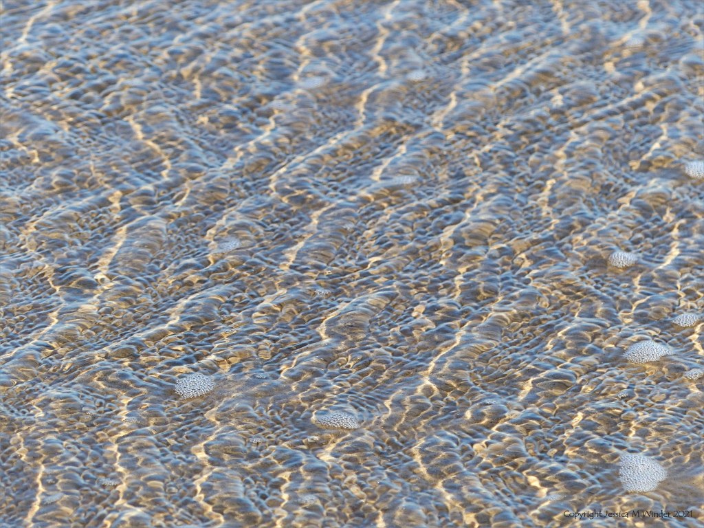 Natural surface texture and pattern of shallow waves breaking on a sandy beach
