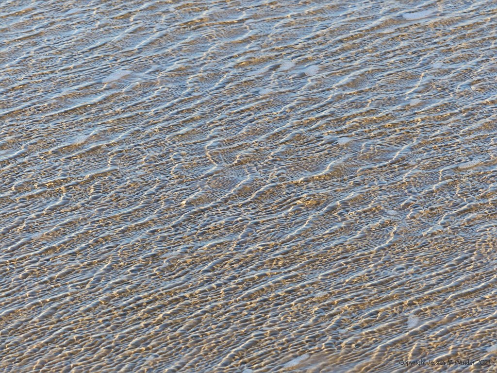 Natural surface texture and pattern of shallow waves breaking on a sandy beach