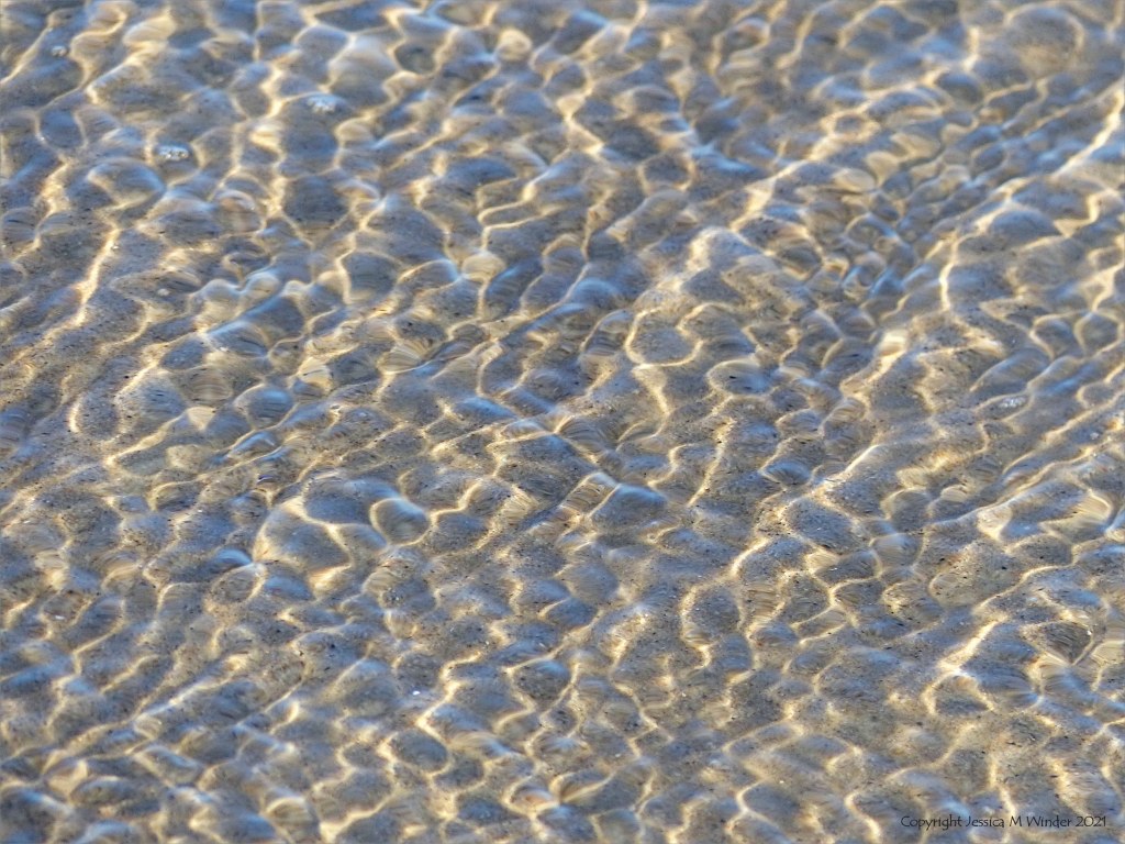 Natural surface texture and pattern of shallow waves breaking on a sandy beach