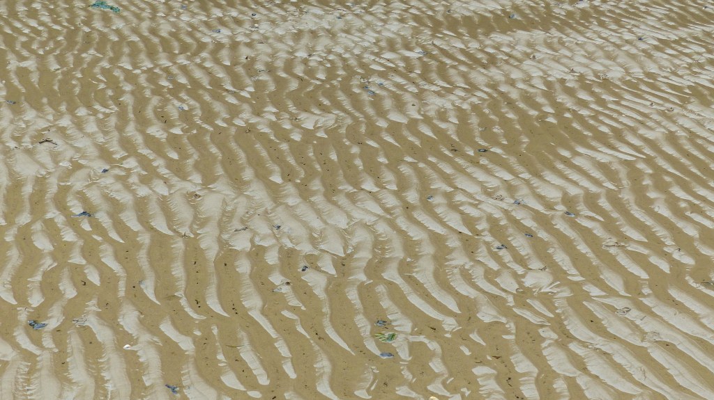 Wet sand ripple patterns on the beach