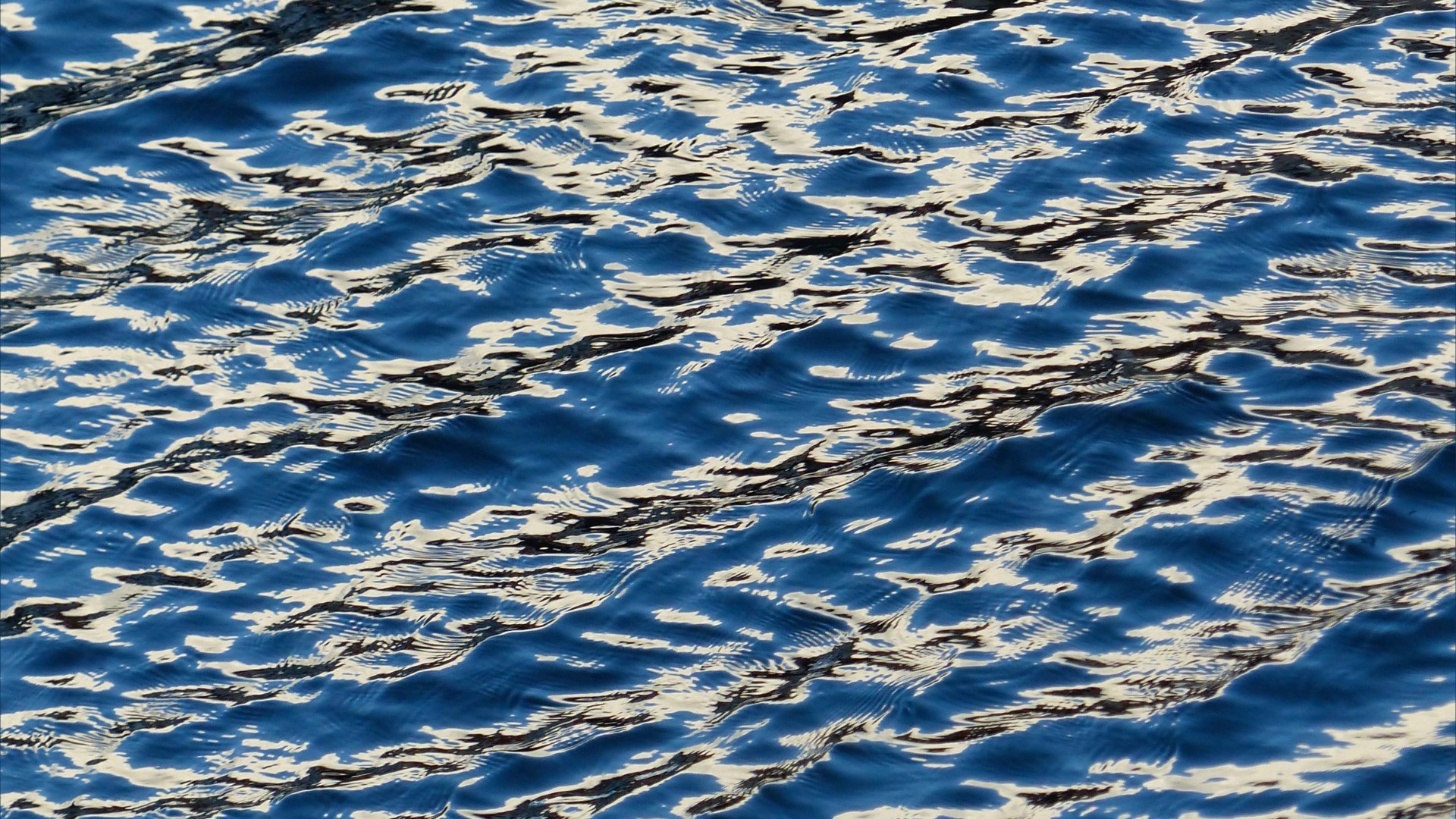 Detail of sea water pattern, texture, and light reflection