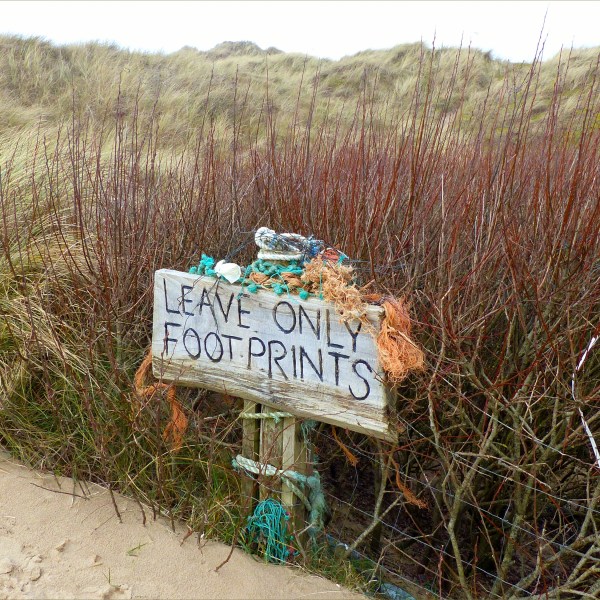 "Leave only footprints" sign on the beach