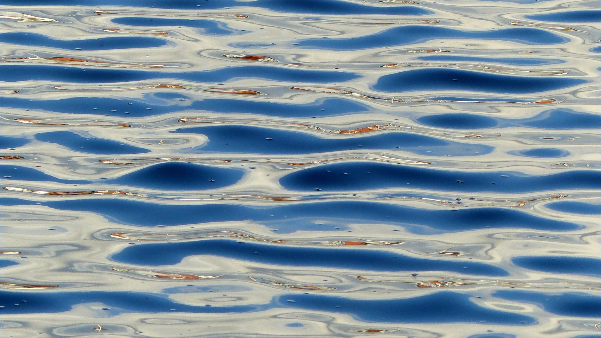 Detail of sea water pattern, texture, and light reflection