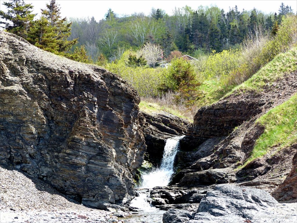 Rock texture, colour, and pattern in eroding Silurian mudstone with stream and waterfall