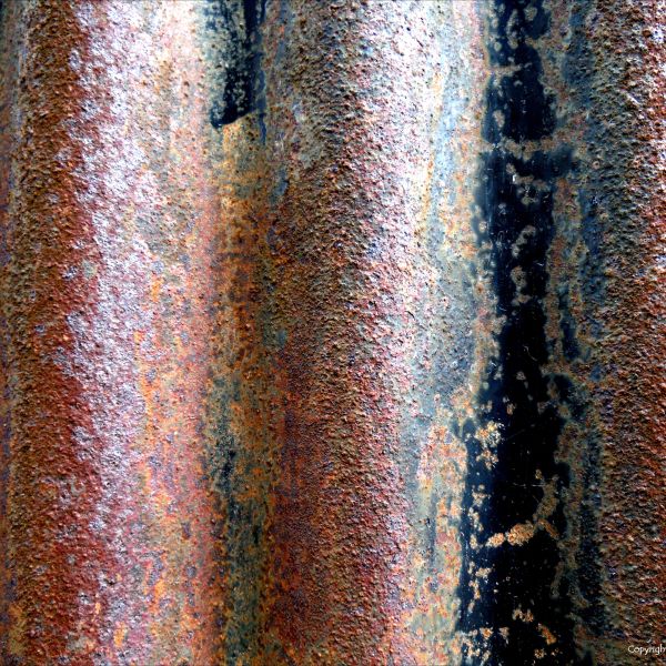 Detail of rust texture and patterns with old paint on corrugated iron