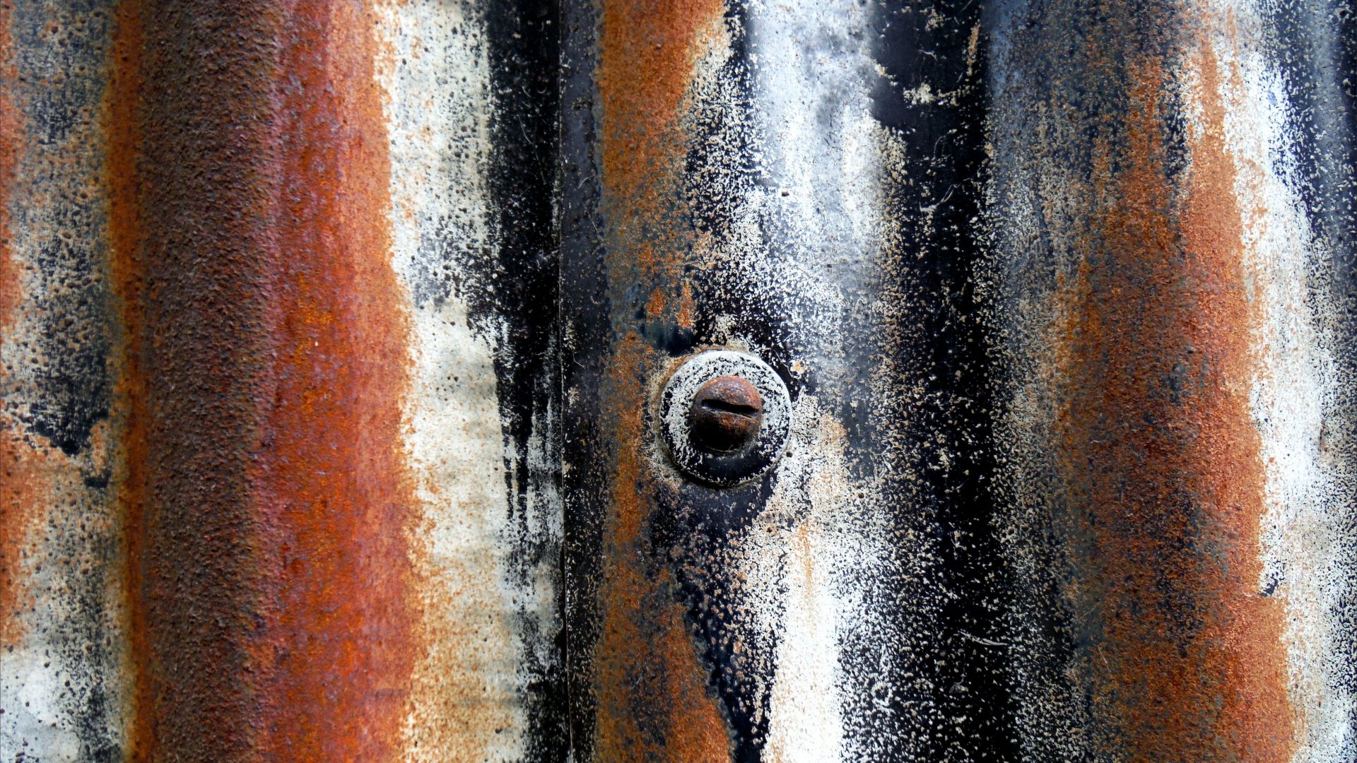 Detail of rust texture and patterns with old paint on corrugated iron