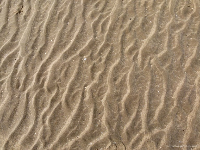 Natural abstract pattern on the surface of sand at the beach