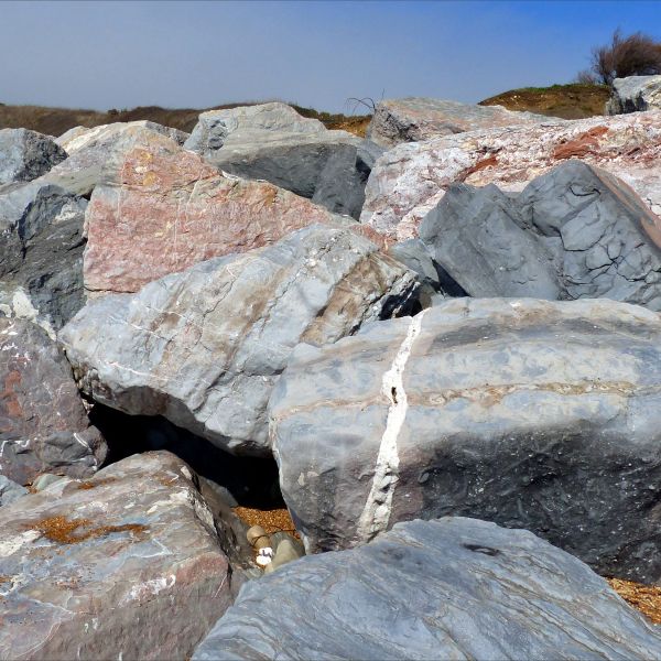 Rip-rap boulders or sea armour (sea defence) on the beach with different patterns and textures