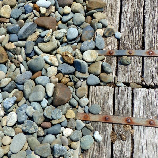 Pebbles on the beach with wooden platform.