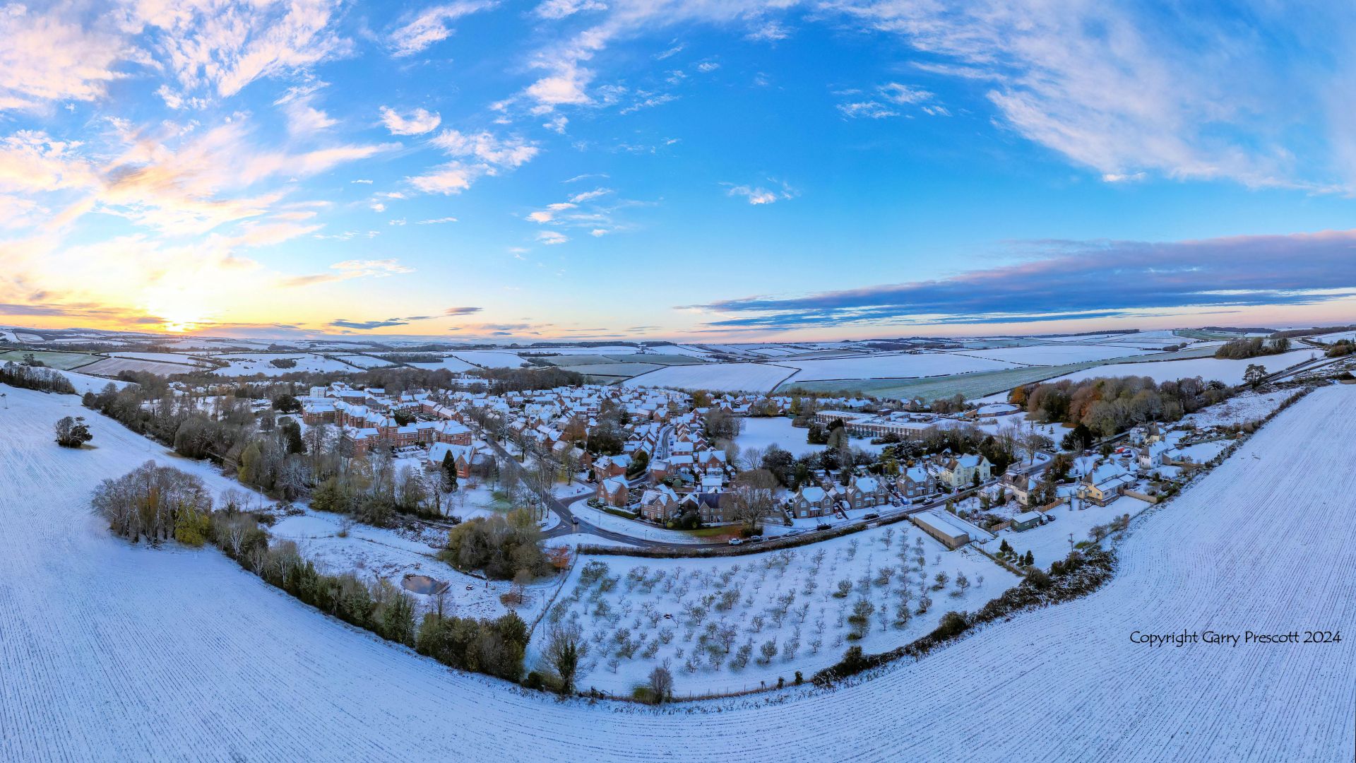 Aerial photograph of snowy Dorset landscape with the village of Charlton Down showing the Nature Area and Community Orchard in the foreground. Drone image by Garry Prescott.