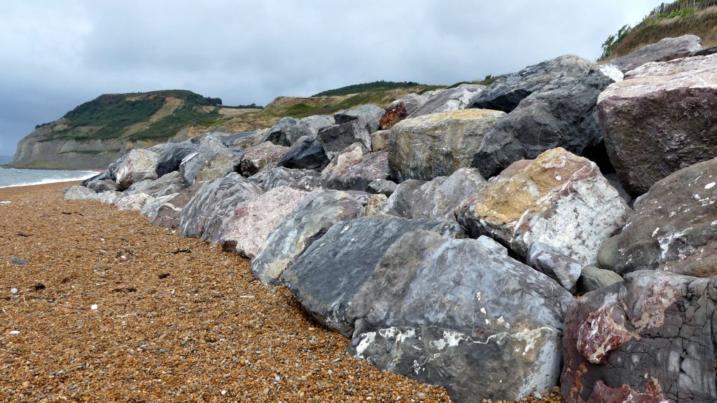 Rock armour or rip-rap sea defence of large imported boulders on the beach at Seatown in Dorset in the Jurassic Coast