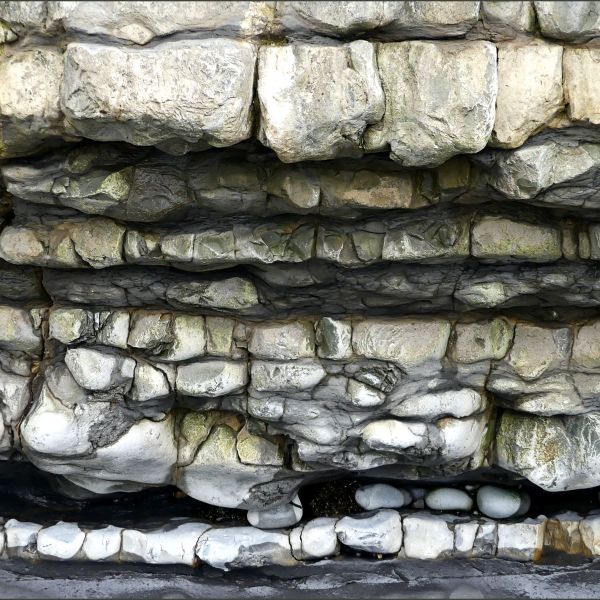 Jurassic limestone and shale rock layers in the vertical crumbling face of a cliff at Dunraven Bay on the Glamorgan Heritage Coast.