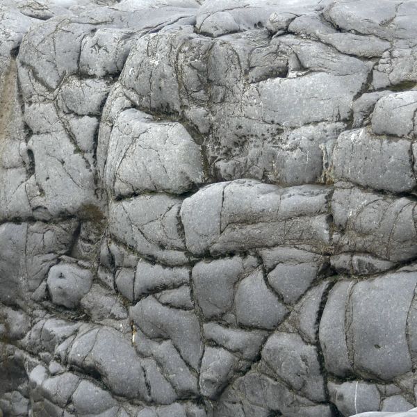 Water-worn Pembroke Limestone Carboniferous era wave-cut platform with accumulation of pebbles on the beach at Ogmore-by-Sea on the Glamorgan coast in South Wales